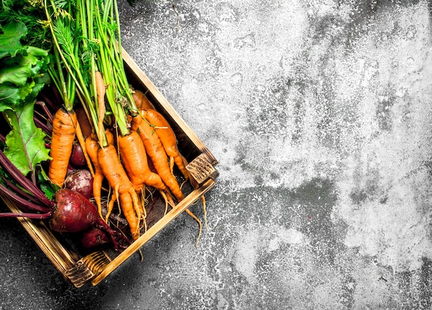 Jedzenie organiczne. Warzywa w starym pudełku. Na rustykalnym tle.