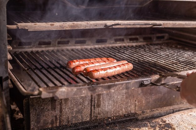 Jedzenie, rzemiosło i pyszna koncepcja - gotowanie kiełbasek na grillu.