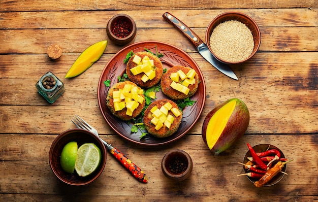 Jedzenie wegańskie, kotlet z komosy ryżowej przyozdobiony mango. Pieczony burger wegetariański