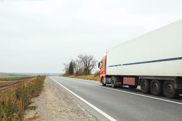 Zdjęcie jedzie ciężarówką po asfalcie jesienią