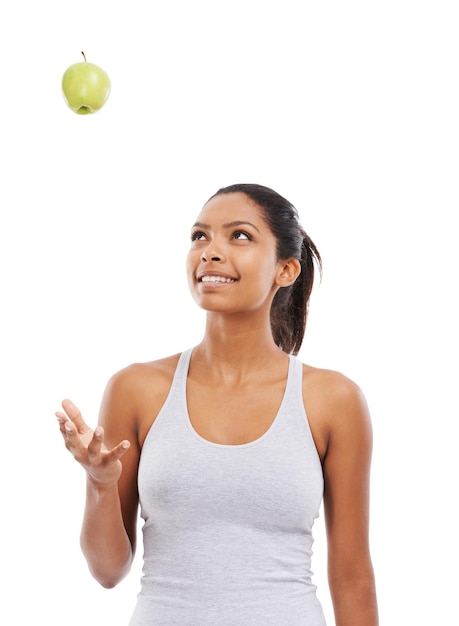Jej plan żywieniowy nigdy się nie udaje Zdrowie Fitness Ładna młoda kobieta rzuca jabłko w powietrze, gdy jest odizolowana na białym tle