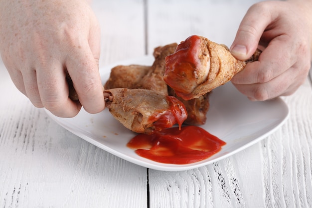 Jeść Niezdrową Udkę Z Kurczaka Z Keczupem