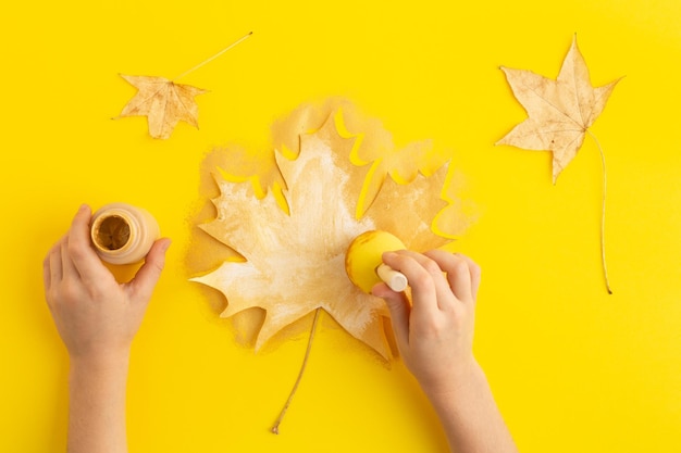 Zdjęcie jesień koncepcja flatlay kolekcja liści klonu pomalowane w złoto na żółtym diy wysokiej jakości zdjęcie