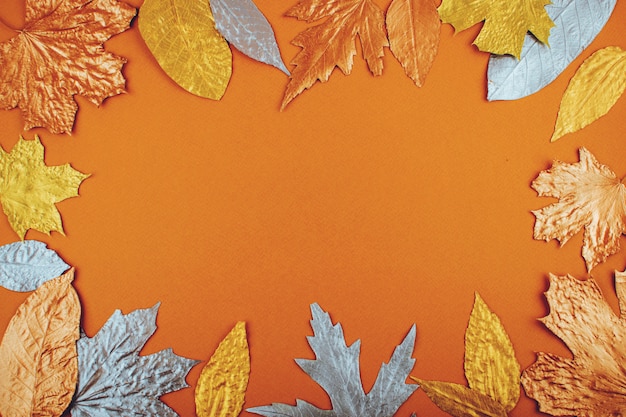 Jesień liści złota rama na pomarańcze papieru tle
