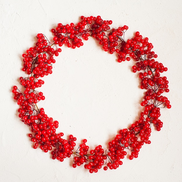Zdjęcie jesień skład z czerwoną jagodą. wieniec wykonany z jagód kaliny.