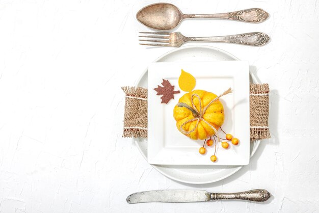 Jesień ustawienie stołu Święto Dziękczynienia sztućce tradycyjny jesienny dekor płaski układ świąteczny przytulny nastrój minimalistyczny projekt twardy światło ciemny cień biały tło masło górne widok