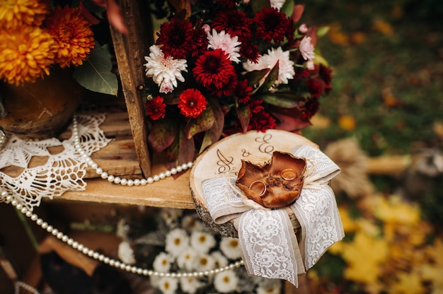 Jesienna ceremonia ślubna na ulicy na zielonym trawniku. Udekoruj łukami świeżych kwiatów na uroczystość.