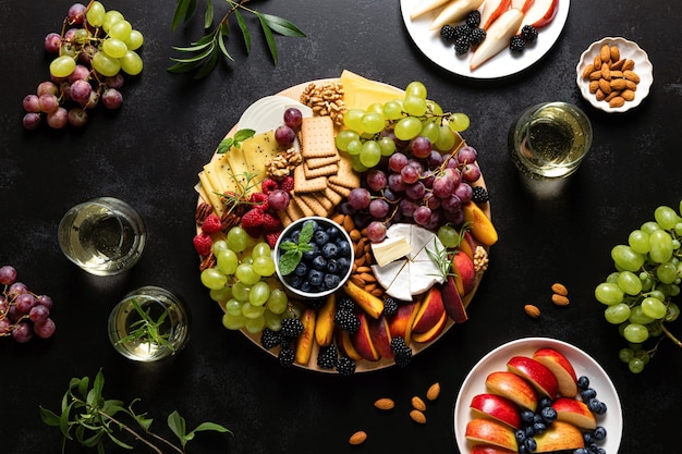 Jesienna deska serów ze świeżymi owocami i jagodami podawana z białym winem z góry