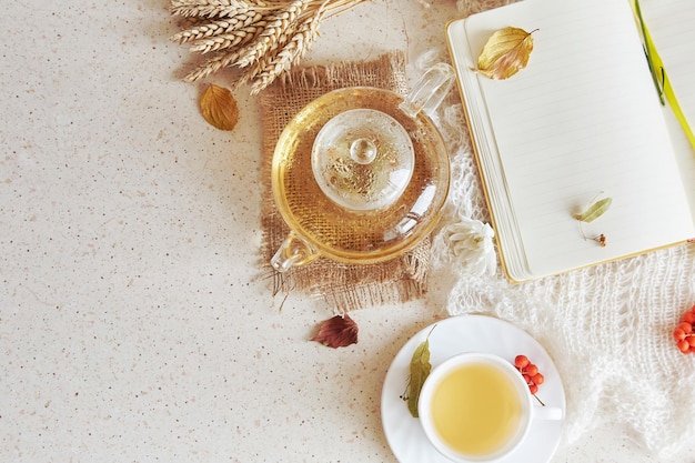 Jesienna estetyczna organiczna herbata lipowa w czajniczku z filiżanką herbaty, makieta notatnika. Przytulna atmosfera w domu