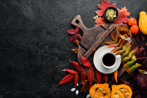 Zdjęcie jesienna kompozycja filiżanka kawy i kolorowe jesienne liście leżące płasko na czarnym kamiennym tle widok z góry wolne miejsce na tekst