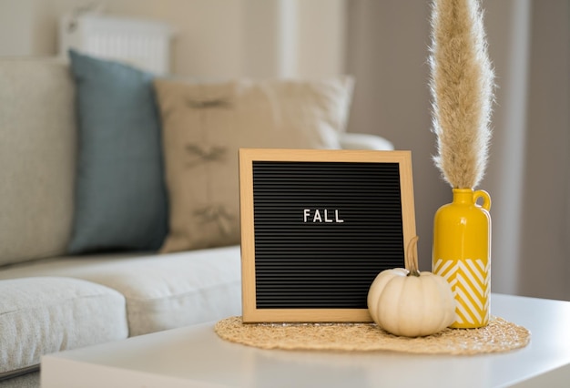 Jesienna kompozycja wnętrza domu Słowo spada na tablicę białą dynięPrzytulna koncepcja dekoracjiWakacyjna atmosfera na Halloween