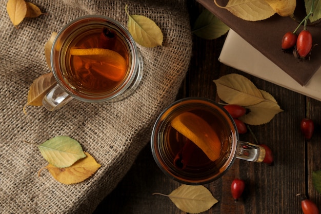 Jesienna kompozycja z gorącą herbatą i suszonymi morelami na brązowym drewnianym stole z miejscem na napis. widok z góry