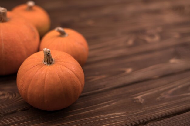 Zdjęcie jesienna mała pomarańczowa dynia na drewnianym stole, żniwa, symbol halloween.