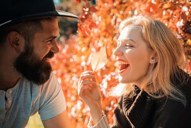 Jesienna para szczęśliwa uśmiechnięta atrakcyjna młoda para na randce siedzi w ulicznej kawiarni w jesiennym dzieleniu