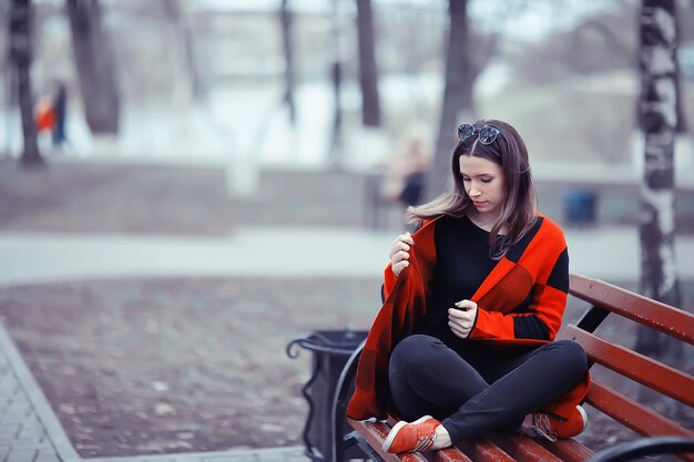 jesienna smutna dziewczyna plener / jesienna pogoda, portret młodej dorosłej dziewczyny w płaszczu w klatce, styl szkocki