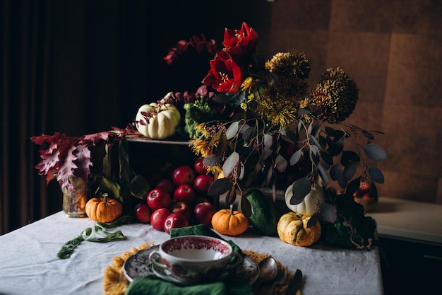 Jesienna uroczysta kolacja w stylu rustykalnym ozdobiona kwiatami i warzywami na ciemnym tle