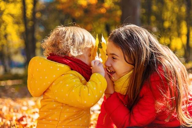 Jesienne dziecko w parku z żółtymi liśćmi Selektywna ostrość Dzieciak
