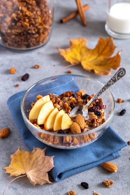 Jesienne owsiane śniadanie muesli z jabłkami na szarym stole