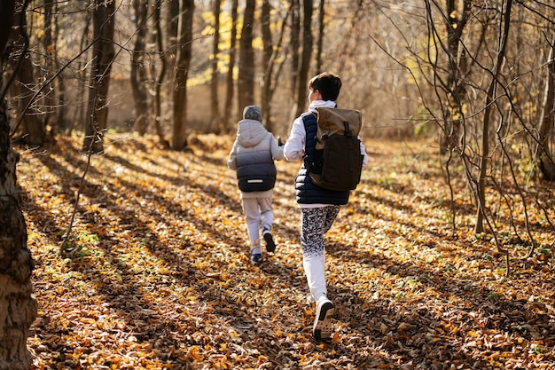 Jesienny plenerowy portret dwóch braci spacerujących po lesie