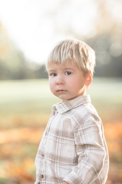 Jesienny portret 23-letniego dziecka w ogrodzie Jesienny sezon Zbliżony widok wesołego słodkiego chłopca