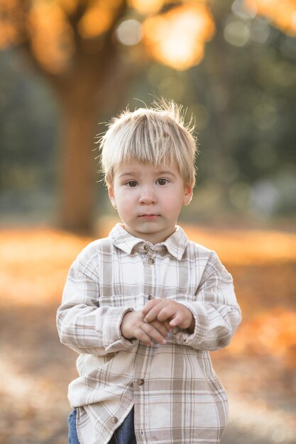 Zdjęcie jesienny portret 23-letniego dziecka w ogrodzie jesienny sezon zbliżony widok wesołego słodkiego chłopca