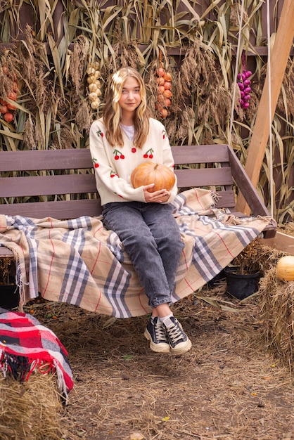 jesienny portret pięknej dziewczyny z dynią na halloween w pobliżu domu