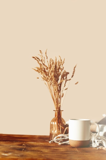 Jesienny układ scen. filiżanka kawy, drewniane deski do krojenia i suszone kwiaty w słońcu.