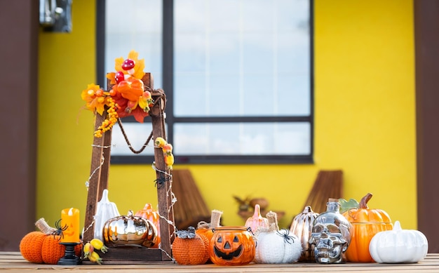 Zdjęcie jesienny wystrój na werandzie domu na podwórzu z latarnią dyniową, girlandami, czapkami z dyni, imprezą z okazji halloween, jesiennym nastrojem, dożynkami