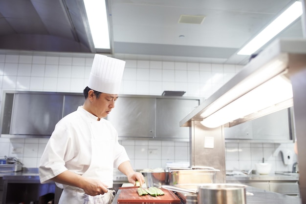 Jest specjalistą od sushi Ujęcie kucharzy przygotowujących obsługę posiłków w profesjonalnej kuchni