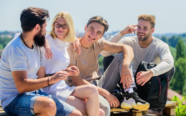 Jesteśmy rodziną. szczęśliwi mężczyźni i dziewczyna odpoczywają. Grupa ludzi w stroju casual. najlepsi przyjaciele. Letnie wakacje. zróżnicowani młodzi ludzie rozmawiający ze sobą. grupa czterech osób. świetnie pasuje na dzień wolny.