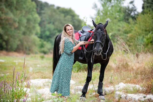 Jeżdżąca dziewczyna idzie ze swoim czarnym koniem