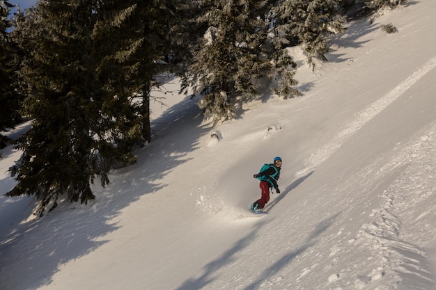 Jeździec na snowboardzie freeride w alpejskim terenie backcountry na ośnieżonym zboczu lawiny