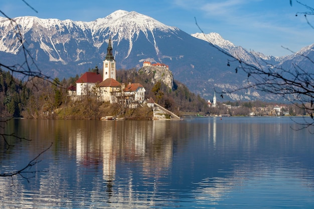 Jezioro Bled na tle ośnieżonych szczytów górskich wczesną wiosną Słowenia Europa