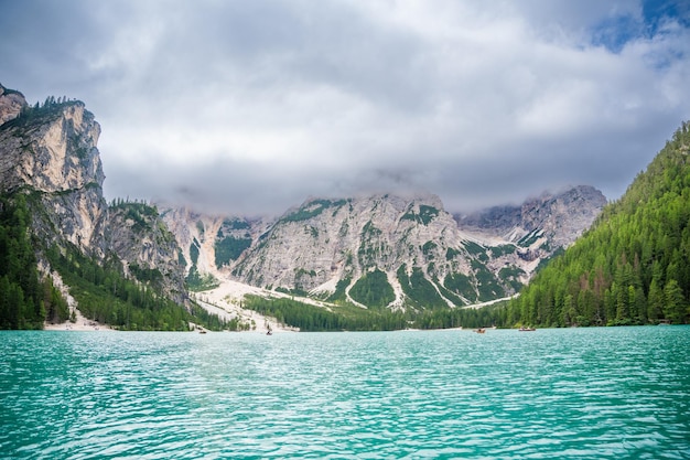 Jezioro Braies otoczone lasami sosnowymi i skalistymi pasmami Dolomitów w chmurny dzień we Włoszech