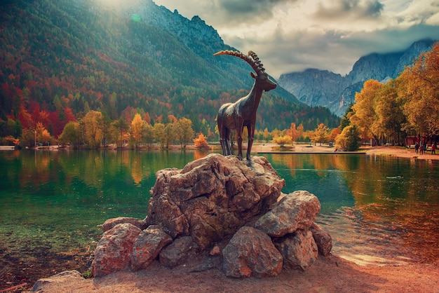 Zdjęcie jezioro jasna z pomnikiem kozic górskich z przodu. park narodowy triglav, słowenia