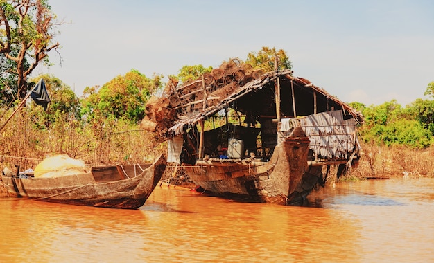 Jezioro Tonle Sap. Pływająca wioska rybacka Kampong Phluk w porze suszy. Domy na palach, ludzie i łodzie. Biedny kraj. Życie i praca mieszkańców Kambodży na wodzie, niedaleko Siem Reap, Kambodża