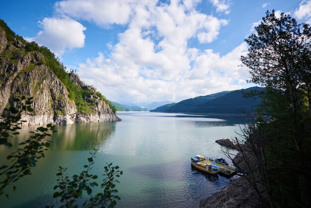 Zdjęcie jezioro vidraru, sztuczne jezioro w rumunii w górach fagaras. błękitne niebo z chmurami nad nim