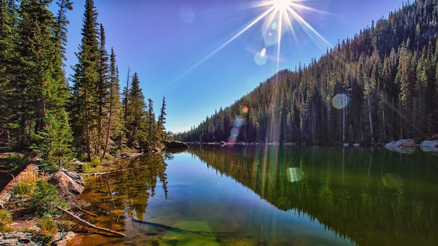 Zdjęcie jezioro w górach ze słońcem świecącym na wodzie