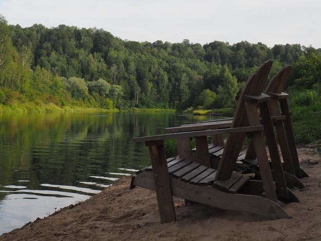 Jezioro z jeziorem i drewnianym krzesłem na brzegu.