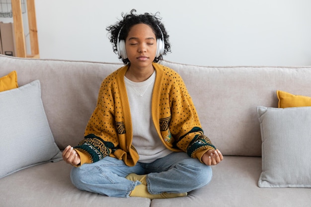 Joga medytacja uważności młoda zdrowa afrykańska dziewczyna ćwicząca jogę w domu siedząca kobieta