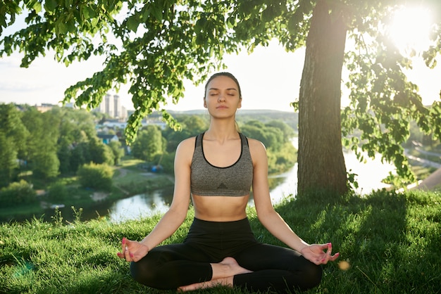 joga w przyrodzie na trawie w pobliżu rzeki