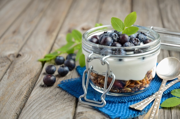 Jogurt parfait z granola i świeże jagody, zdrowe śniadanie koncepcji.