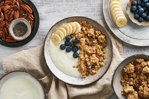 Jogurt z czekoladową granolą, borówka. Śniadanie, zdrowa dieta z płatkami owsianymi