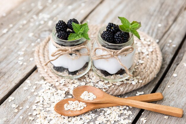 Jogurt z jeżynami w szklanych słoiczkach z naturalnych produktów.