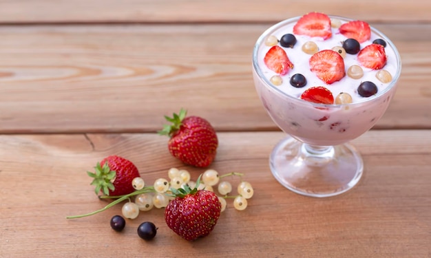 Jogurt z letnimi jagodami na drewnianym stole Zdrowa żywność bogata w witaminy błonnika i przeciwutleniacze