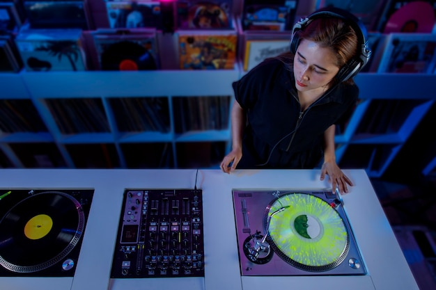 Joven Mujer Dj Latina Mezclando Musica En Una Tienda De Discos De Vinilo