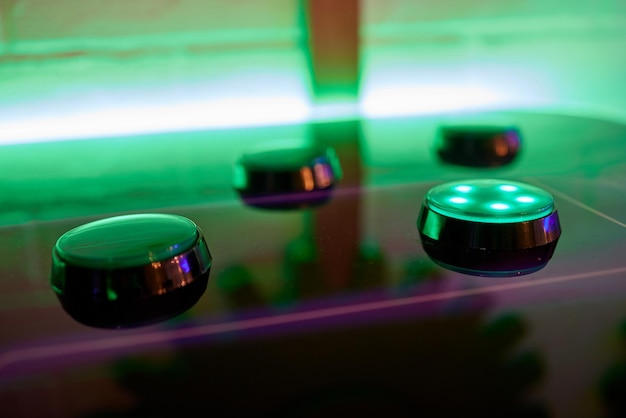 Joystick i przyciski sterujące klasycznej zręcznościowej gry wideo w ciemnym pokoju.