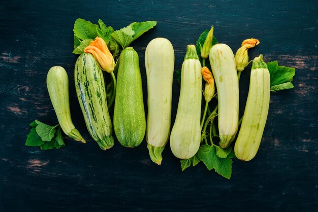 Zdjęcie kabaczek szpik cukinia świeże warzywa na czarnym drewnianym stole widok z góry kopiowanie miejsca