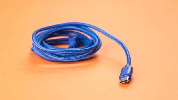 Kabel USB w izolacji z tkaniny na pomarańczowym tle
