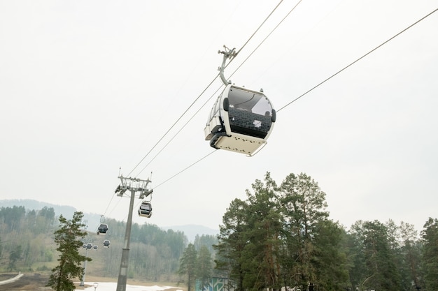 Kabiny wyciągowe w górskim ośrodku narciarskim wyciąg narciarski kolejka linowa na wzgórzach górski ośrodek zimowy w pochmurny dzień wyciąg krzesełkowy kolejka linowa z ludźmi sceniczny panoramiczny szeroki widok na stoki zjazdowe